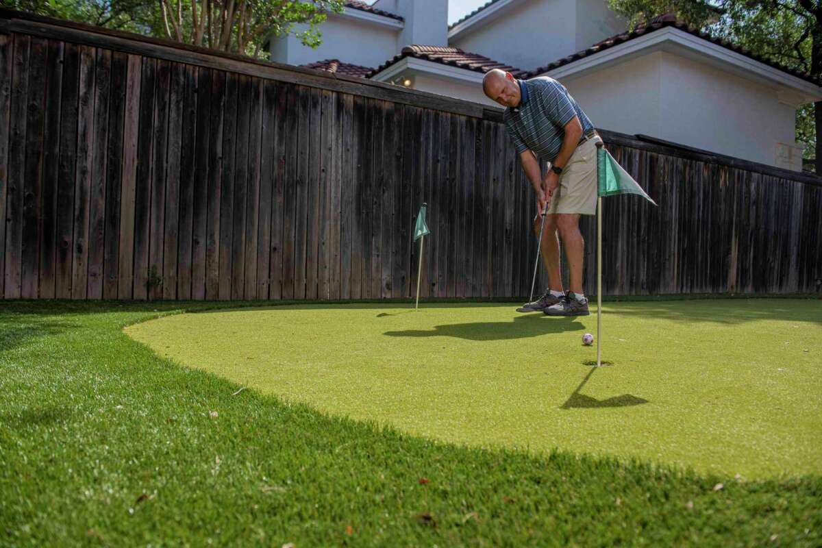 Roger Burg practices on the artificial turf putting green in the backyard of his Rogers Ranch Home.  Burg and his wife Sharon O'Malley Burg installed the fake grass in their yard to help save on water.
