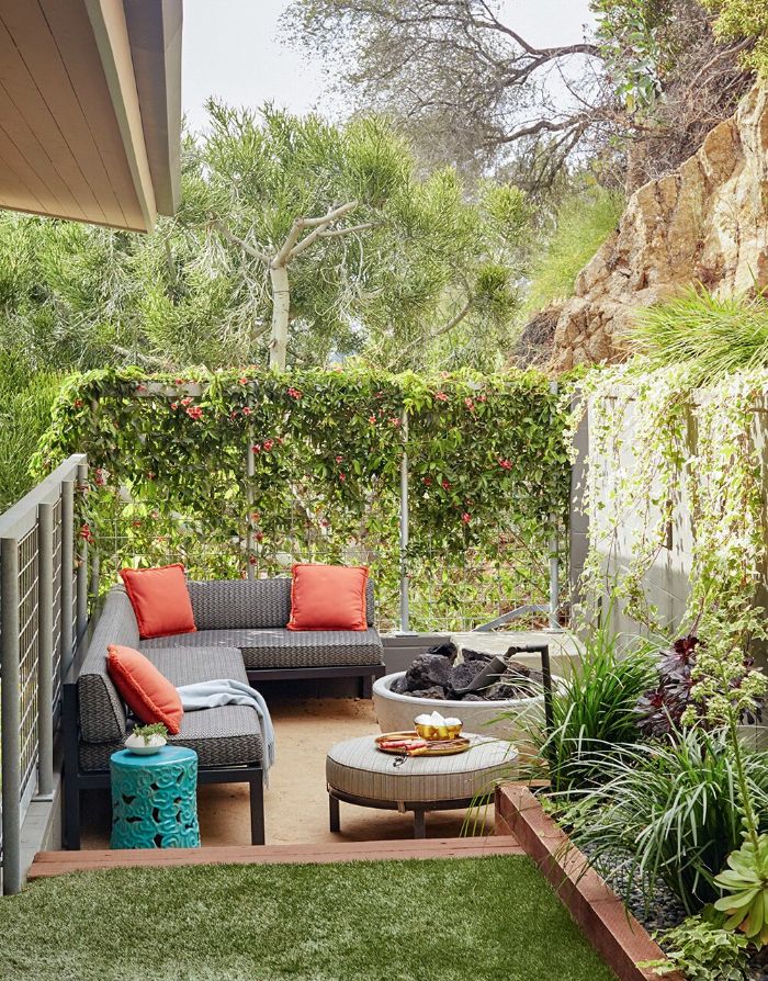 backyard décor ideas small wooden corner sofa with orange throw pillows ottoman next to fire pit