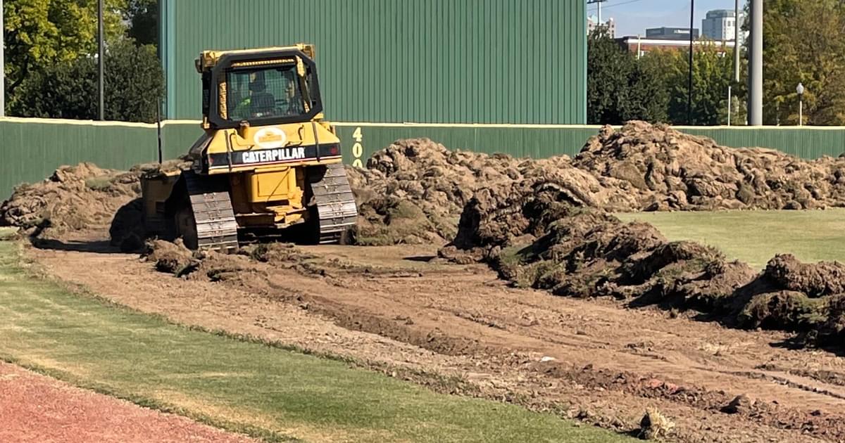 Work is underway on putting new artificial turf, padded outfield wall at Young Memorial Stadium
