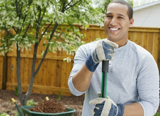 man wearing garden gloves doing yardwork