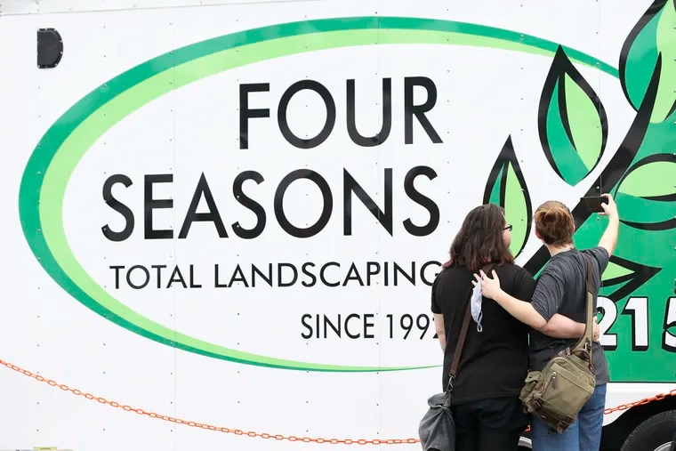 Concertgoers take selfies in front of a Four Seasons Total Landscaping truck before the start of a concert at Four Seasons Total Landscaping, the site of Rudy Giuliani's infamous press conference, in northeast Philadelphia.